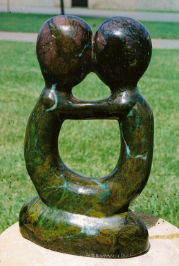 Carved shona Sculpture. Two figures connected by head, arms and legs.